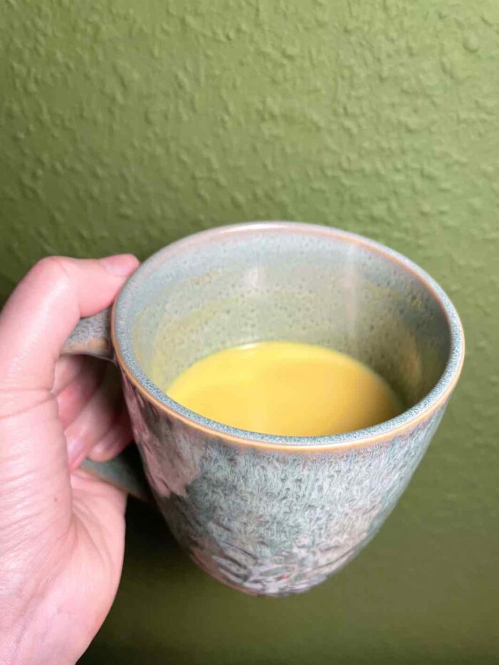 Tasse mit goldener Milch darin (sieht einfach aus wie gelbgefärbte Milch)